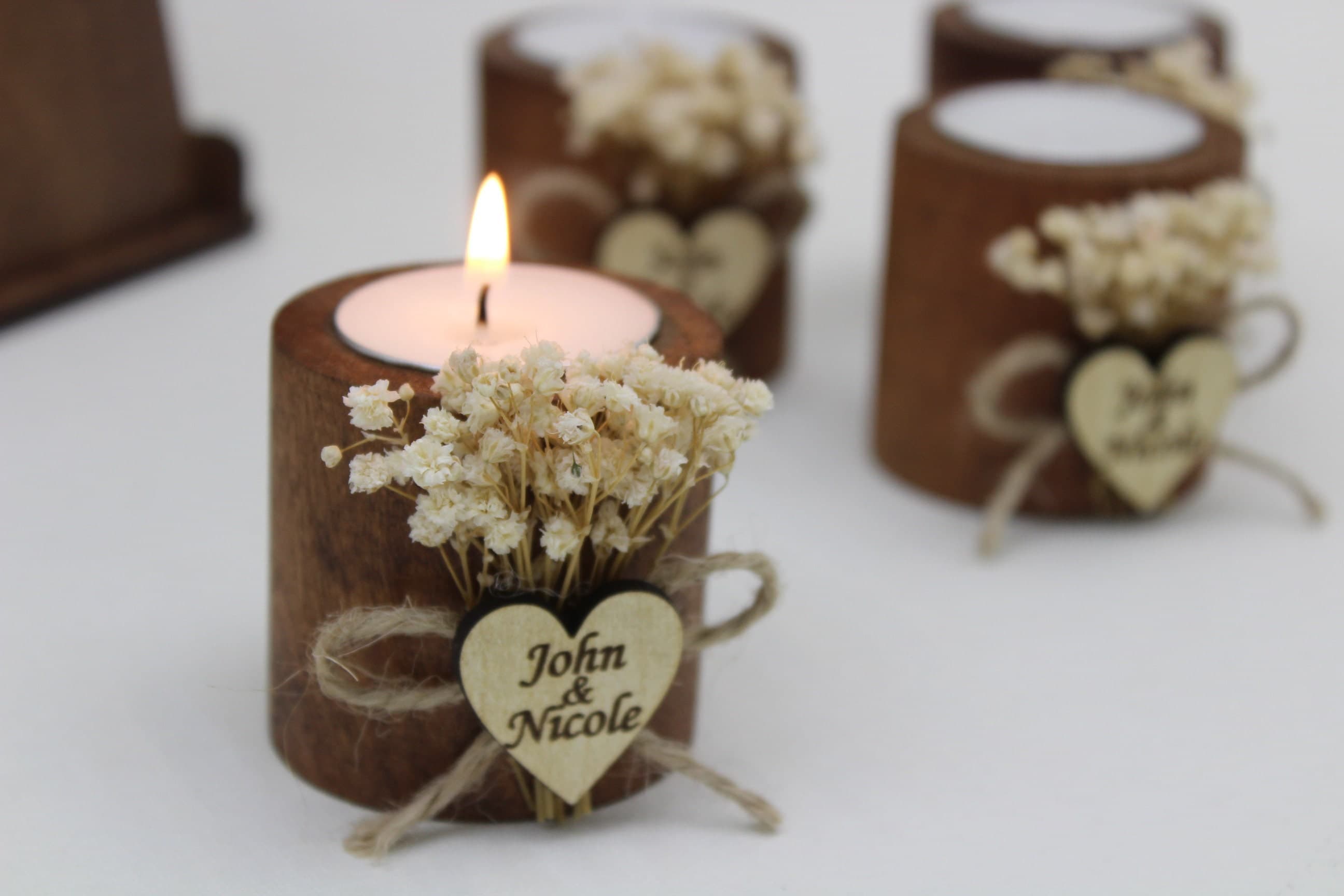 Wooden tealight holder with a small white dried flower posy and a heart tag engraved John and Nicole