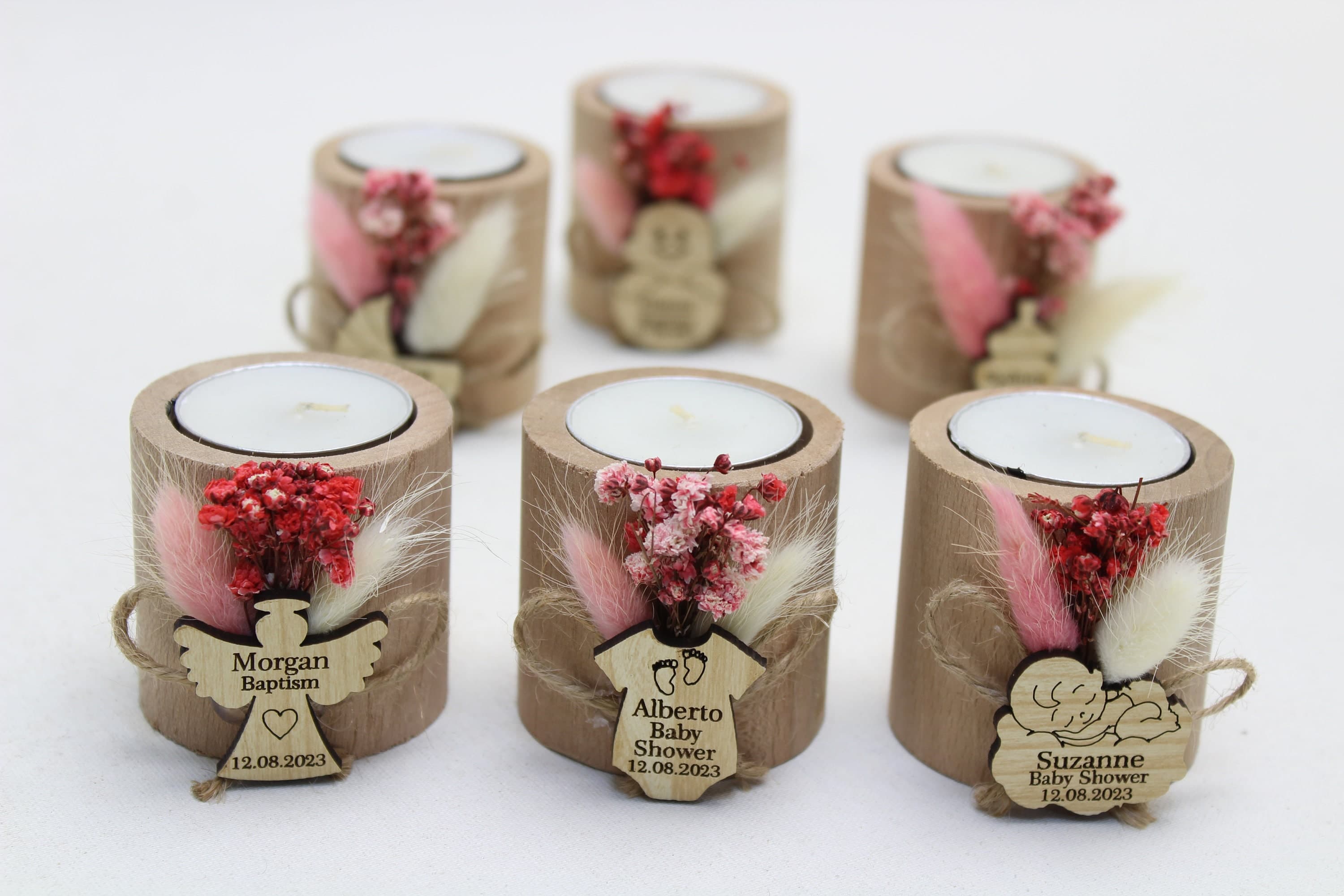 Six wooden slice candle favours with dried flowers and personalised tags reading Morgan Baptism and Alberto Baby Shower