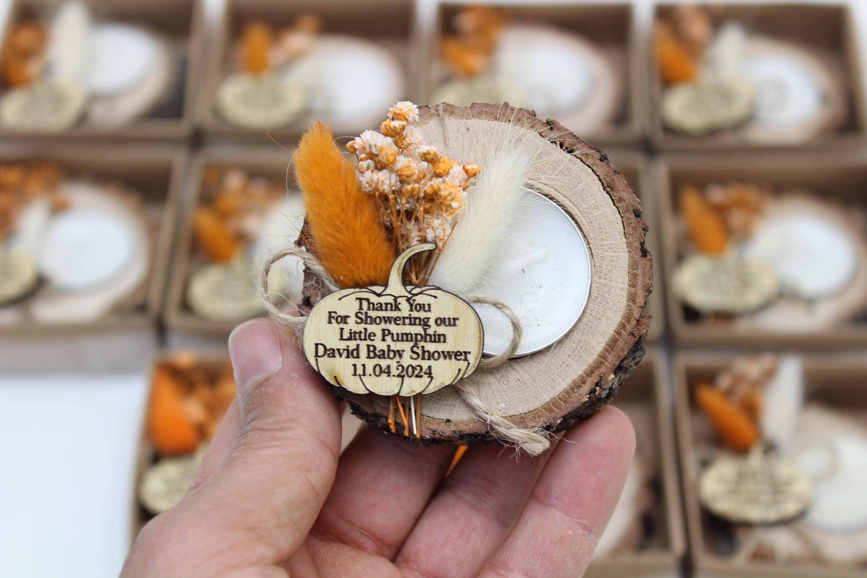 Wooden slice tealight favour with dried flowers and a pumpkin-shaped tag personalised for a baby shower