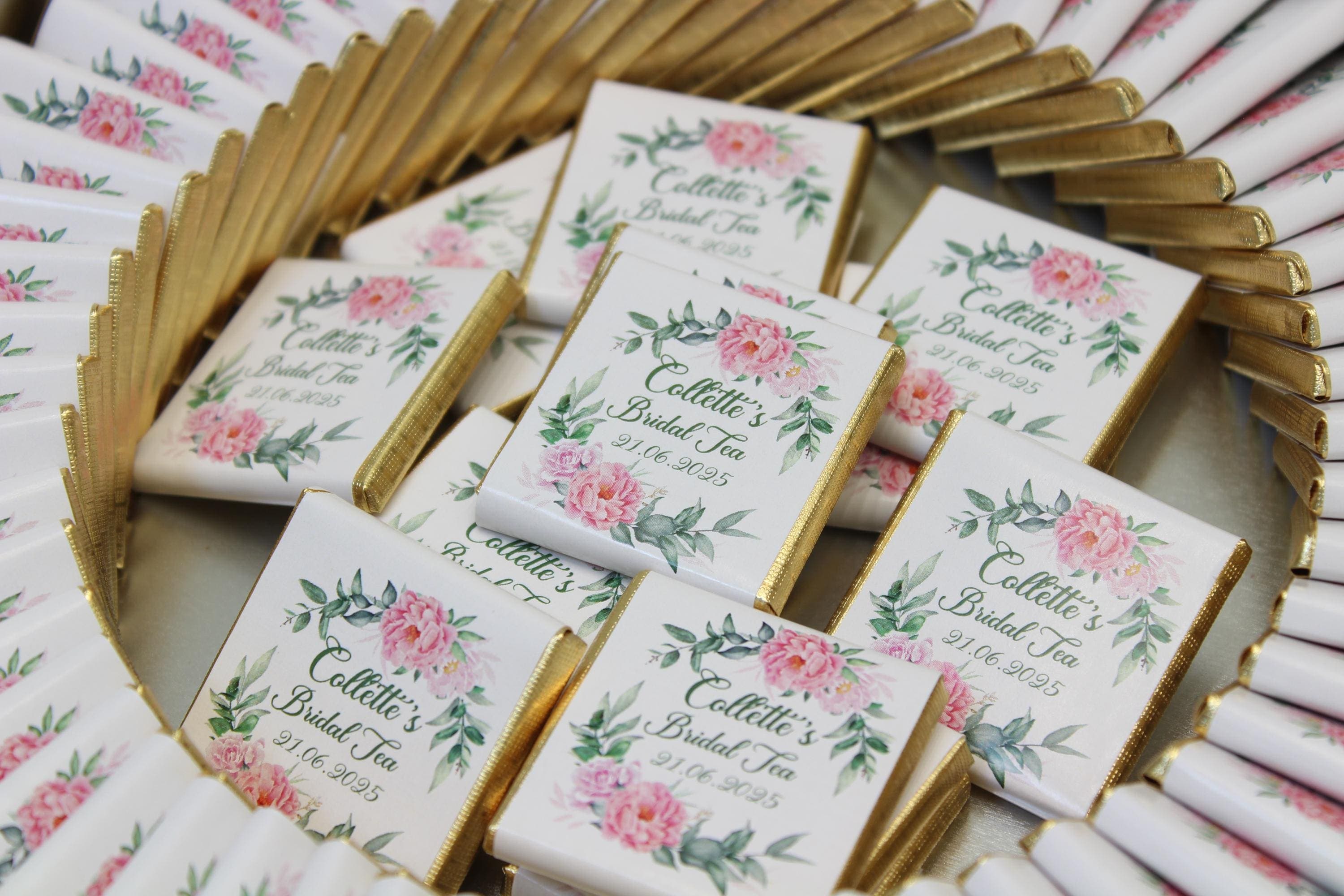 White chocolate favour bars in gold foil printed with a floral design and a bridal tea name and date
